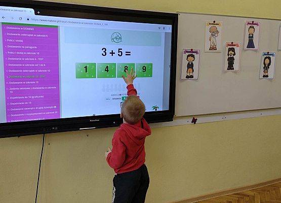 uczeń rozwiązuje zadanie ma interaktywnym monitorze