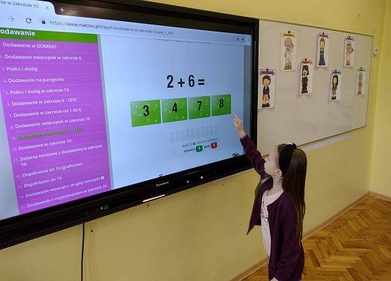 uczennica rozwiązuje zadanie na tablicy interaktywnej