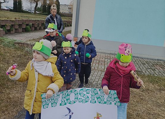 dzieci niosą plakat z napisem wiosna