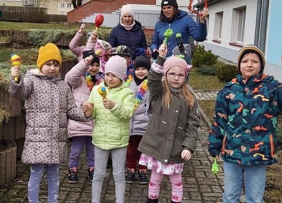 dzieci stoją przed budynkiem przedszkola