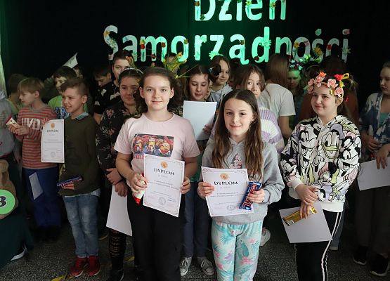 uczniowie stoją w grupie i prezentują dyplomy