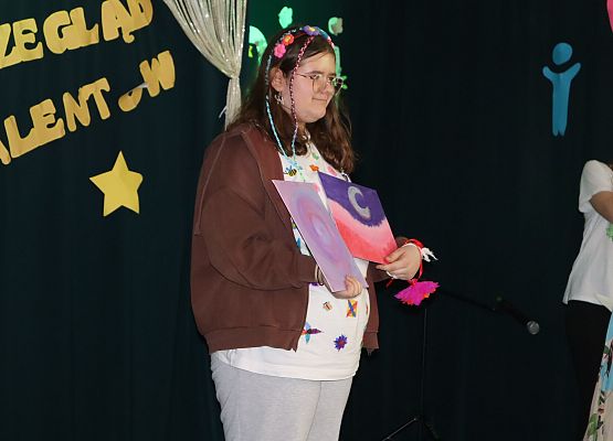 uczennica prezentuje swoje obrazy