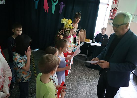 dyrektor wręcza dyplomy dzieciom