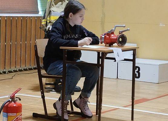 uczennica siedzi przy stoliku  podczas Ogólnopolskiego Turnieju Wiedzy Pożarniczej 2023