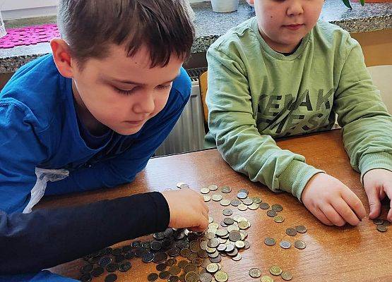 chłopcy segregują monety