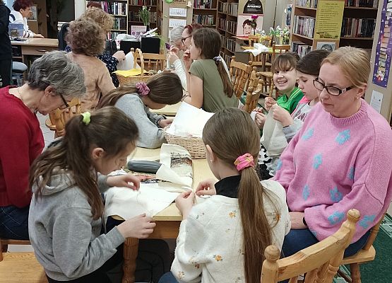 uczniowie z nauczycielką siedzą przy stole podczas warsztatów