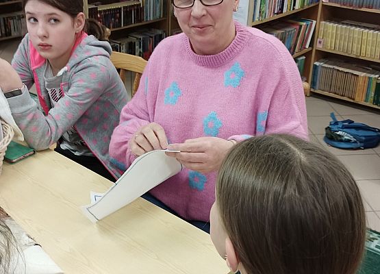 uczniowie i nauczycielka haftują