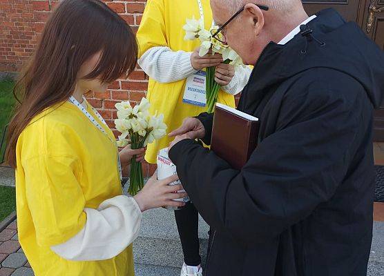 ksiądz proboszcz wrzuca datek do puszki