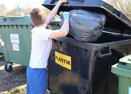 uczeń wyrzuca śmieci do kontenera
