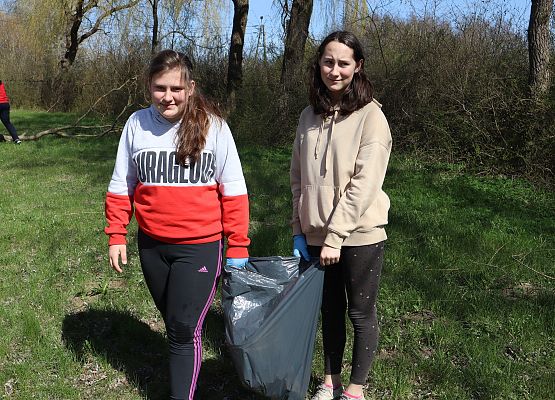 dwie uczennice niosą worek