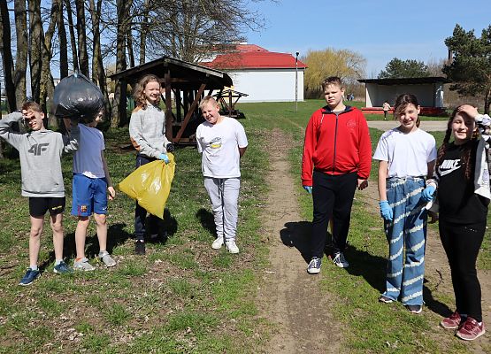 uczniowie sprzątają teren