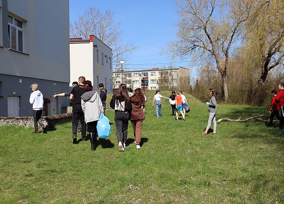 uczniowie sprzątają teren