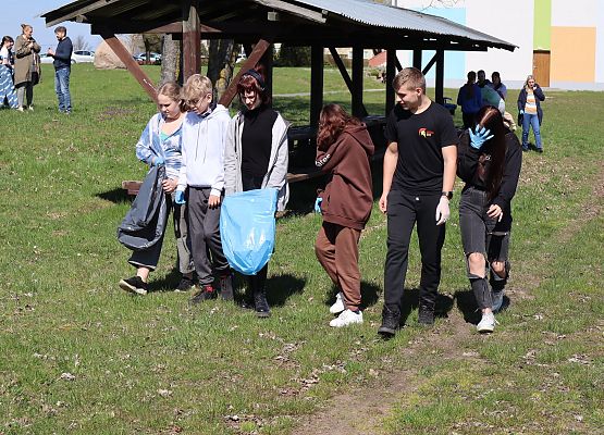 uczniowie sprzątają teren