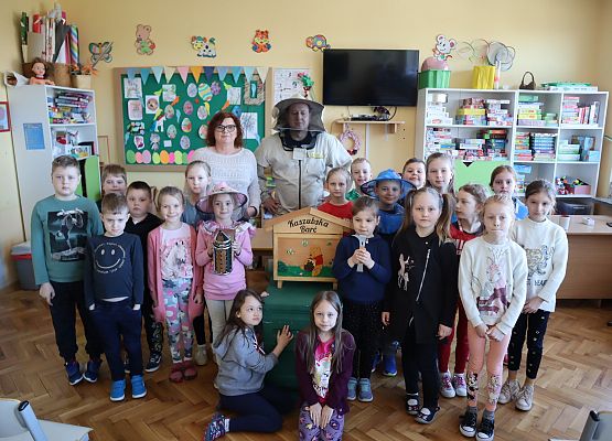 zdjęcie grupowe dzieci z pszczelarzem