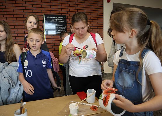 uczniowie robią wazony z puszek