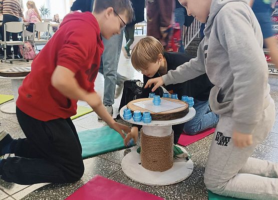 uczniowie grają w gry wykonane z odpadów