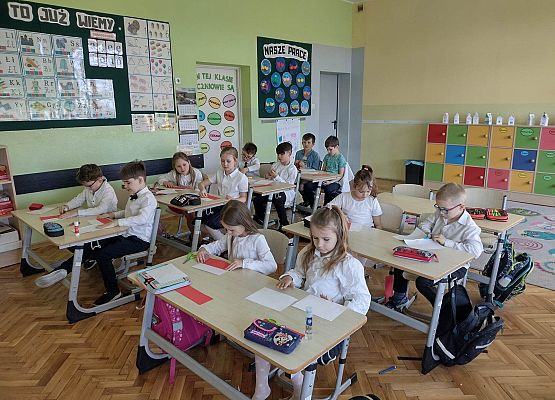 uczniowie wykonują papierowe flagi