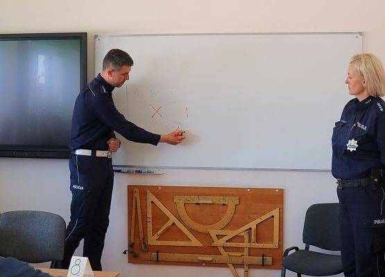 policjant pisze na tablicy