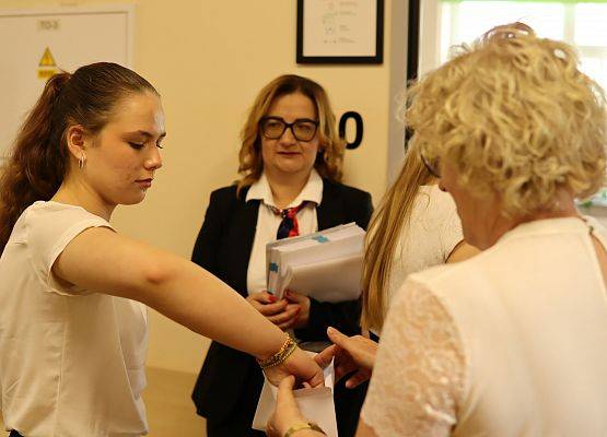 uczennica wyciąga z koperty numerek