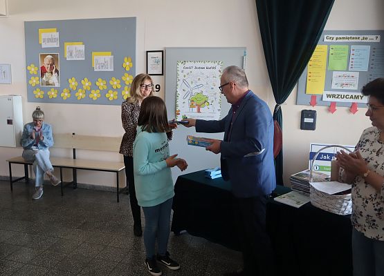 uczennica odbiera nagrodę i dyplom