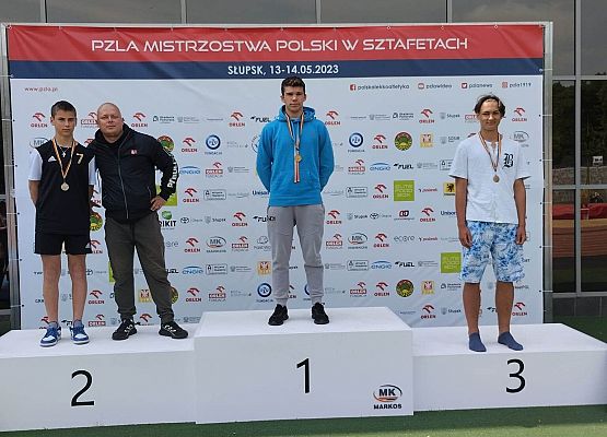 sportowcy stoją na podium