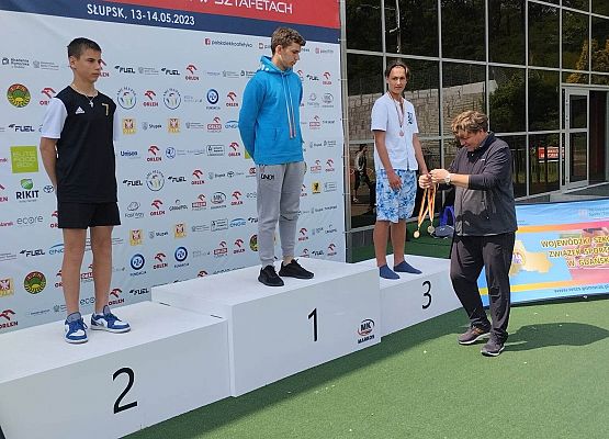 sportowcy stoją na podium