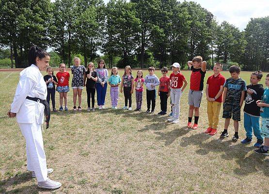 kobieta pokazuje uczniom układy karate