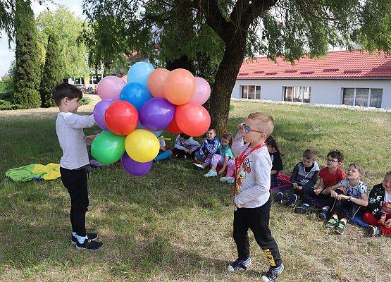 chłopiec trzyma kolorowe balony