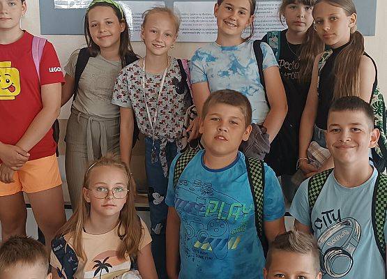 grupa uczniów na tle gazetki szkolnej