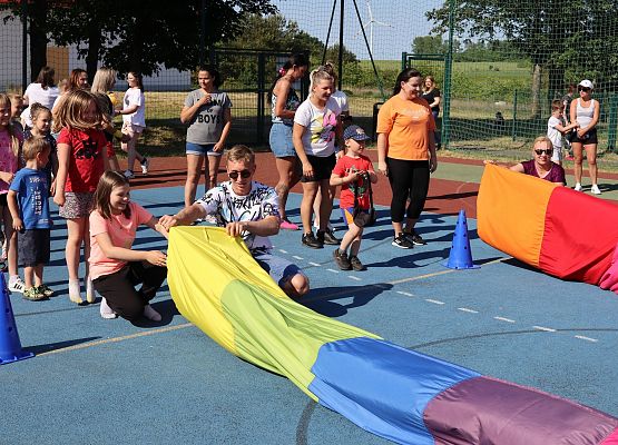 dzieci i rodzice przechodzą przez kolorowy tunel