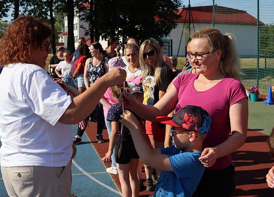 nauczycielka wręcza uczestnikom medale