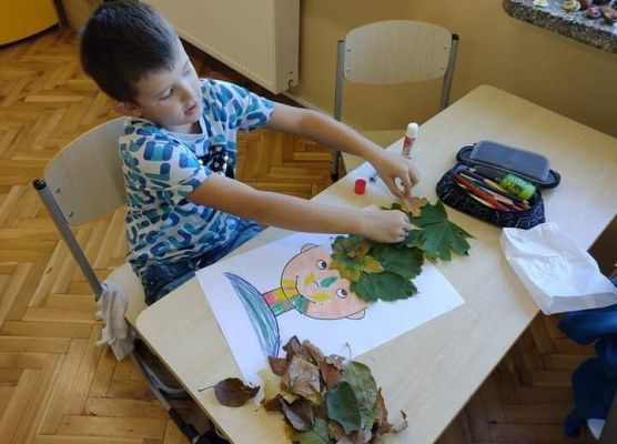 chłopiec wykonuje pracę plastyczną