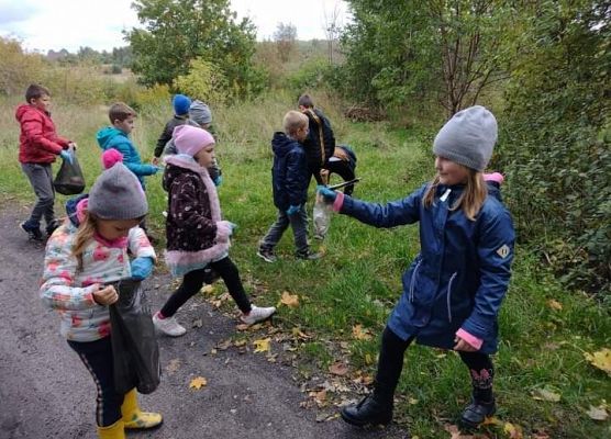 uczniowie sprzątają otoczenie