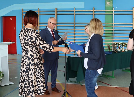 dyrektor i wychowawca wręczają świadectwo uczennicy