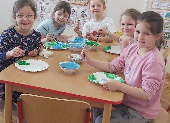 dzieci malują farbami papierowe talerze