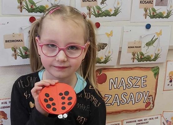 dziewczynka prezentuje swoją pracę plastyczną