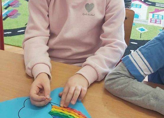 dziewczynka prezentuje swoją pracę plastyczną