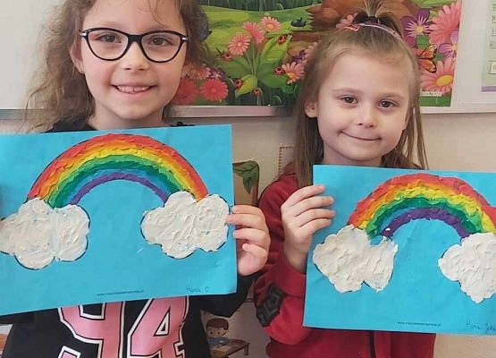 dziewczynki prezentują swoje prace plastyczne