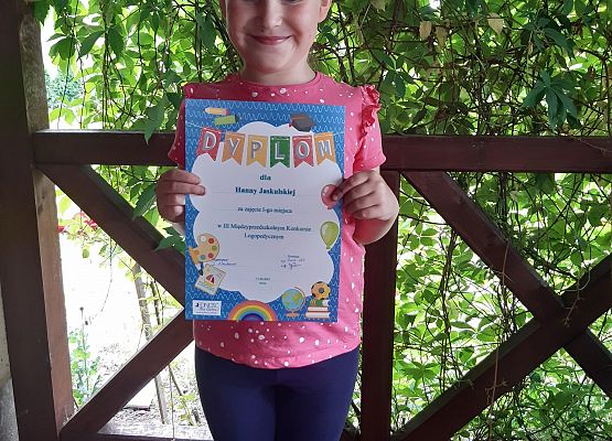 dziewczynka prezentuje dyplom