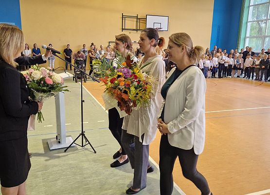 rodzice wręczają kwiaty nauczycielce