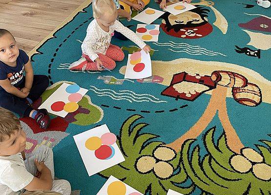 dzieci siedzą na dywanie