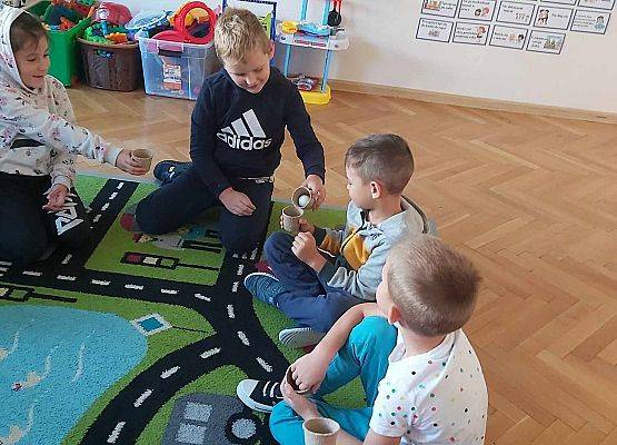 dzieci siedzą na dywanie