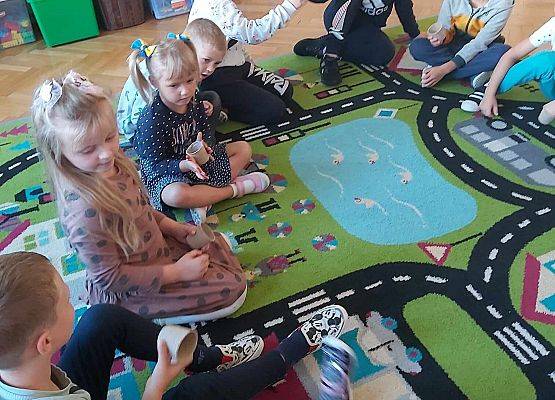 dzieci siedzą na dywanie