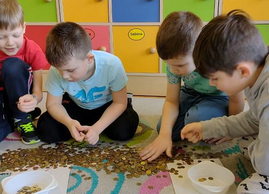 uczniowie segregują monety