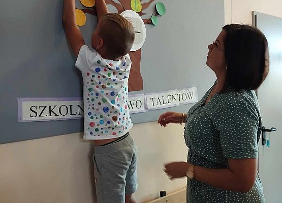 uczeń wiesza kropki na tablicy