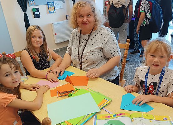 uczniowie z nauczycielką podczas warsztatów origami