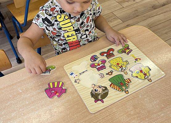 chłopiec układa puzzle