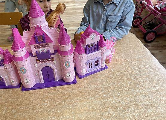 dziewczynki bawią się zamkiem dla lalek