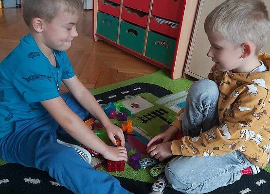 chłopcy bawią się na dywanie