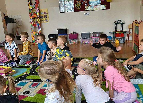 dzieci siedzą na dywanie